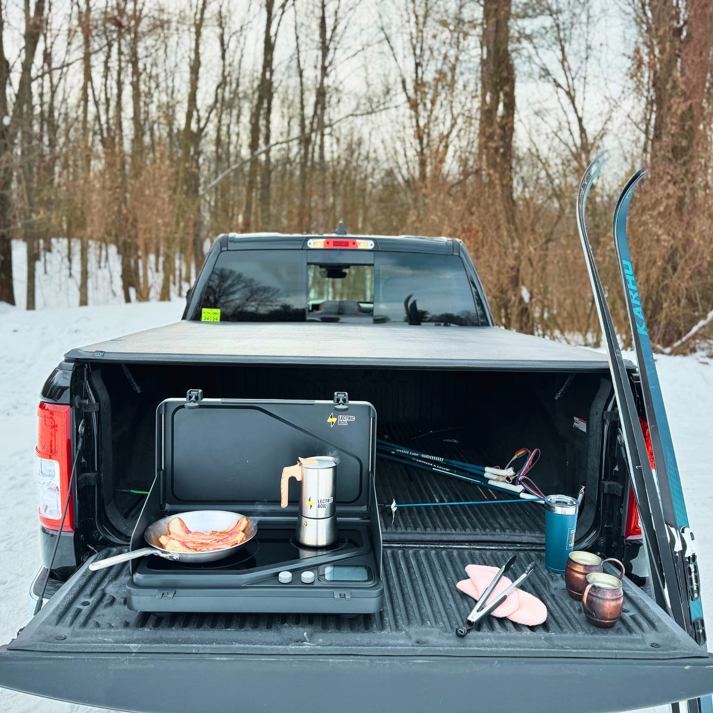 Here is the Lectric Boil cooking in winter on the tailgate. The Lectric Boil patent pending prototype with removable battery generator to recharge your essentials off-grid and removable cutting board. Made in the USA with induction technology. For camping, sustainable camping, glamping,overlanding, off grid living.