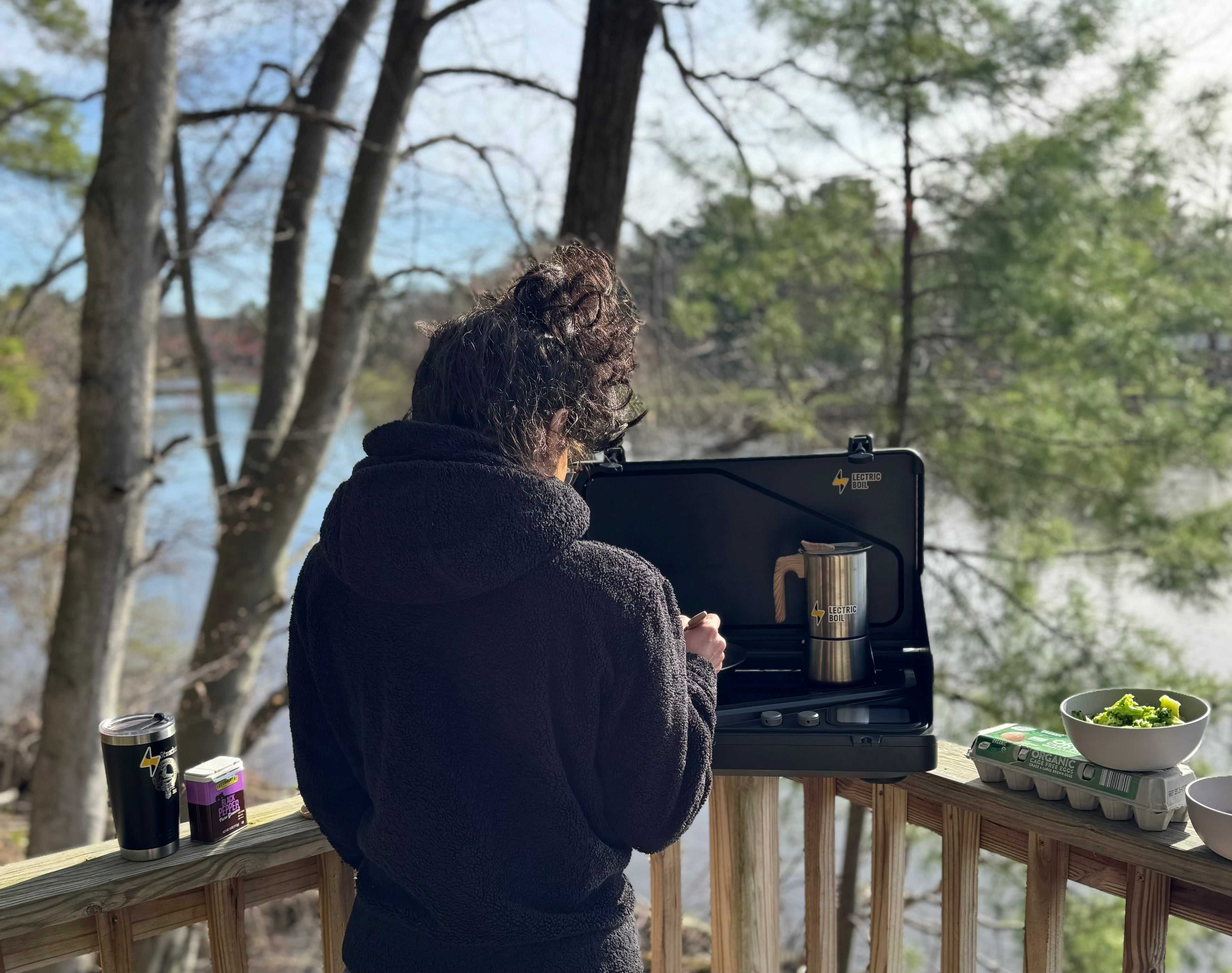 The back of a person with a black hooded sweater cooks in front of the Lectric Boil. The first portable induction stove and generator with a battery and dual burners for campers, outdoor workers, natural disasters — and anyone, anywhere, cooking or surviving off-grid.
#productimage
#overlander
#lifestyle