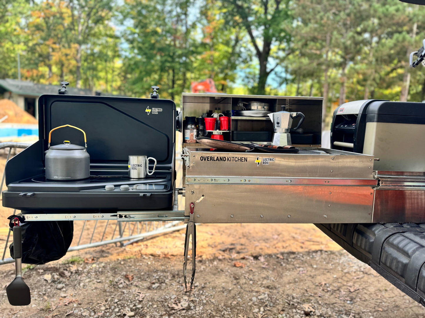 Camper truck with open cargo area and camping gear in a forest setting Lectric Boil on the Overland Kitchen pull out. The first portable induction stove and generator with a removable battery and dual burners for campers, outdoor workers, victims of natural disasters — and anyone, anywhere, cooking or surviving off-grid.
#productimage
#overlander
#lifestyle