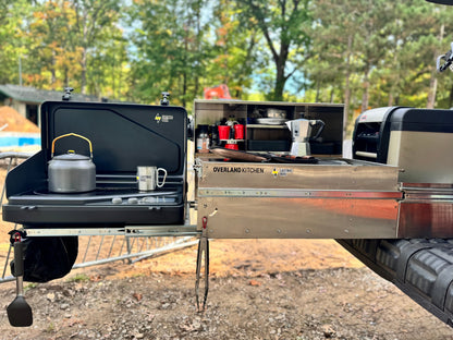 Camper truck with open cargo area and camping gear in a forest setting Lectric Boil on the Overland Kitchen pull out. The first portable induction stove and generator with a removable battery and dual burners for campers, outdoor workers, victims of natural disasters — and anyone, anywhere, cooking or surviving off-grid.
#productimage
#overlander
#lifestyle